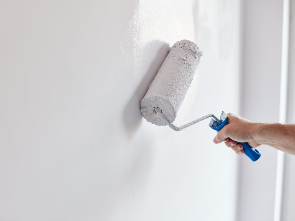 pintor passando tinta impermeabilizante na parede